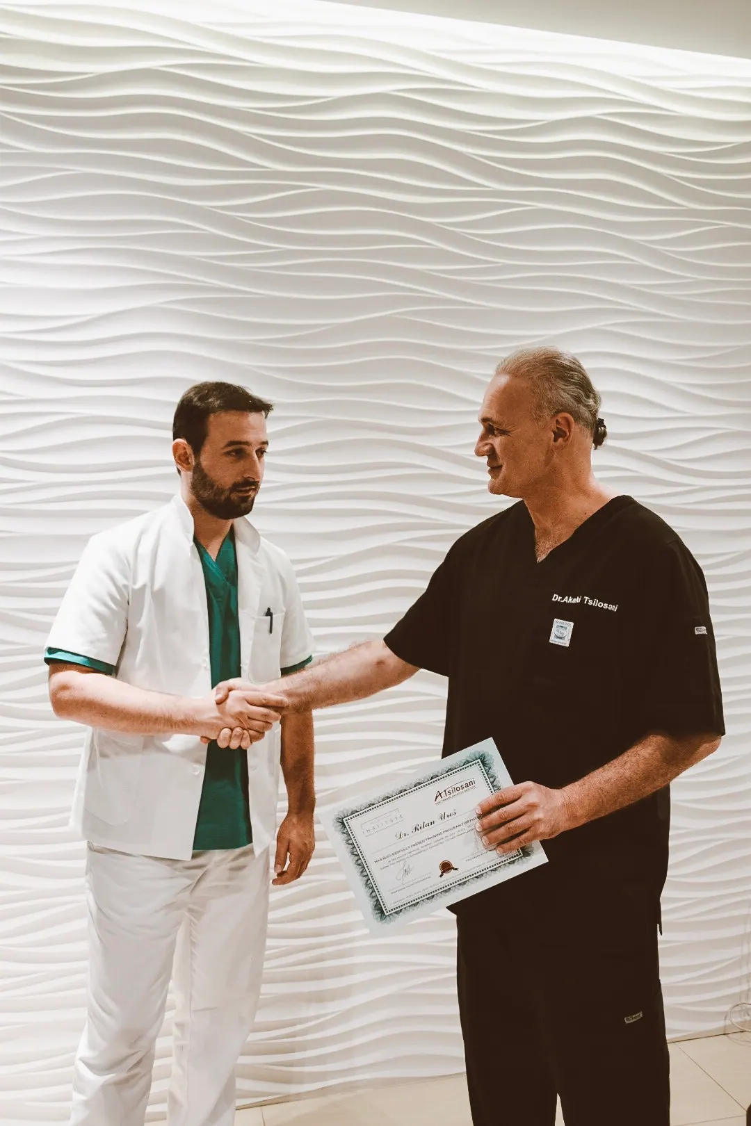 Dr. Tsilosani congratulating a graduate and presenting the course certificate