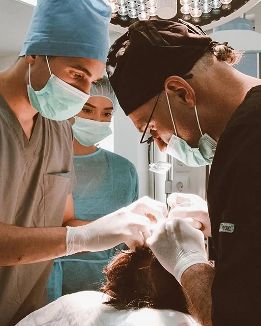 Trainee doctors assisting during a live hair transplant procedure