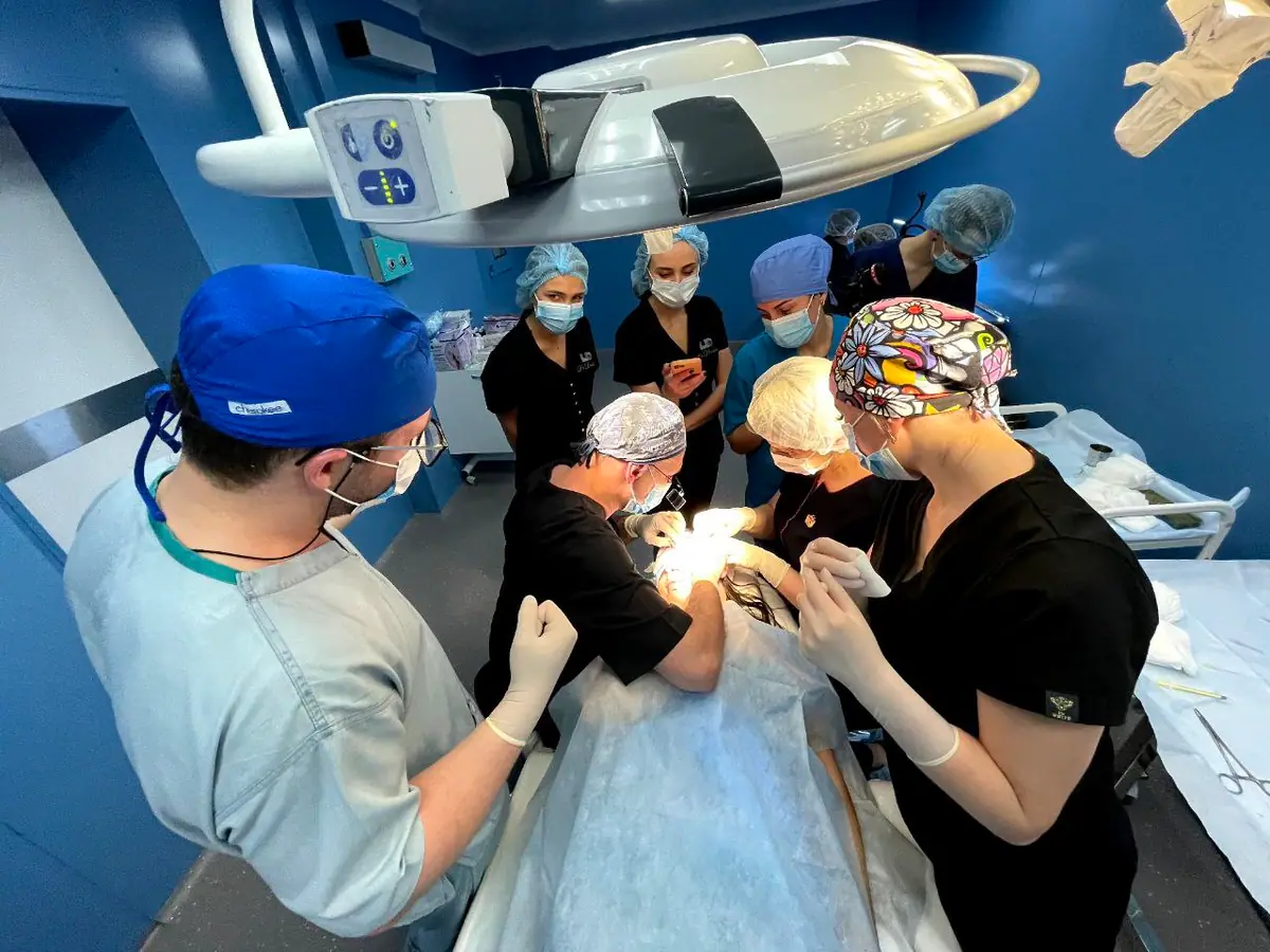 A small group of doctors training together around a live surgical case