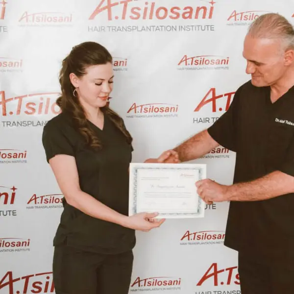 Dr. Tsilosani presenting a course completion certificate to a graduate